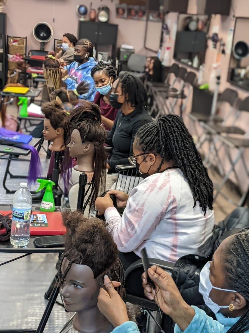 Students practicing braiding techniques on mannequin heads