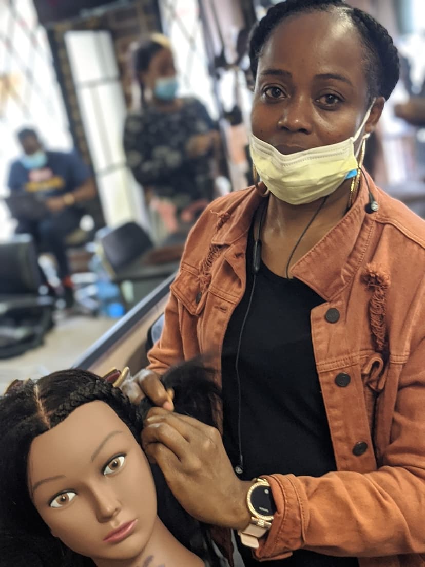 Student practicing cornrows on mannequin head