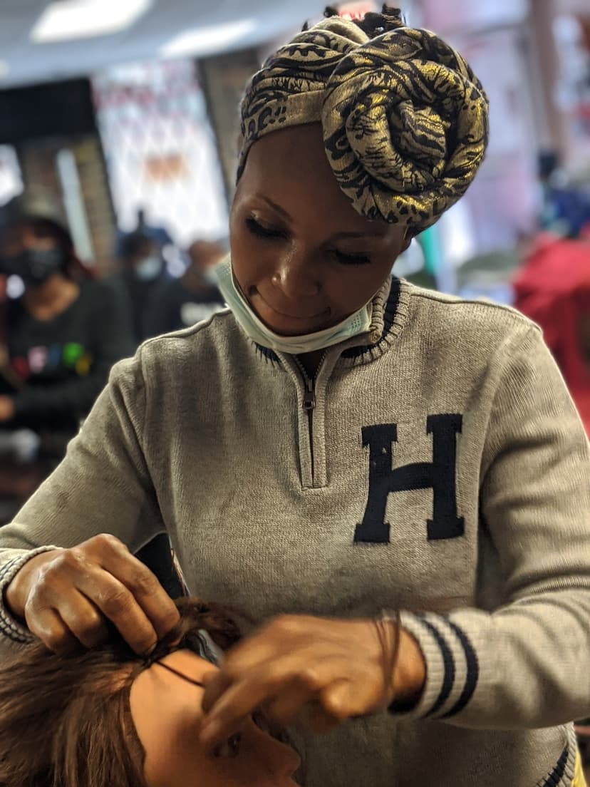 Student braiding on mannequin head in classroom